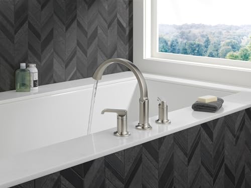 Stainless steel Roman tub faucet with curved spout and two lever handles mounted on white bathtub rim.