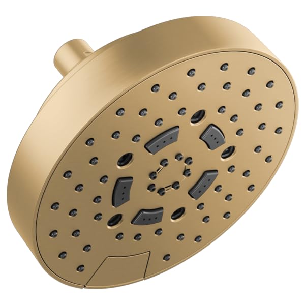 Round brushed gold shower head with multiple spray jets and adjustment buttons mounted on wall.