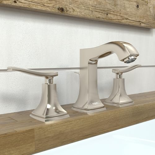 Polished nickel widespread bathroom faucet with squared center body, curved spout, and lever handles on wooden vanity.