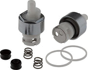 Two stem cartridges with metal bodies, rubber seals, springs, and black caps for faucet repair.