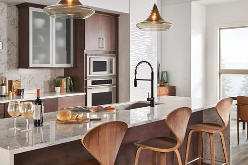 Moen matte black single-hole pulldown kitchen faucet with spring-style neck and pre-rinse sprayer installed at kitchen island