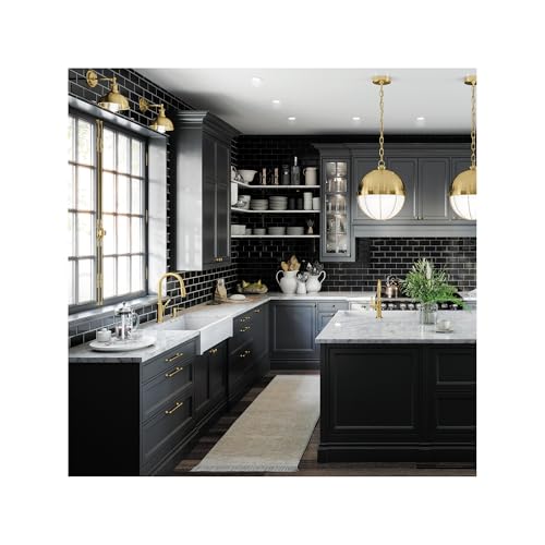 Brushed gold bar faucet installed above sink in modern black kitchen with white countertop.