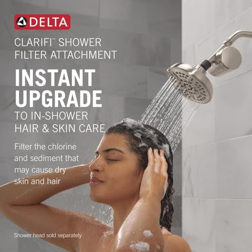Brushed nickel shower filter attachment with round showerhead, water flowing, installed on shower arm.