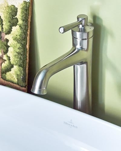 Brushed nickel single-hole bathroom faucet with curved spout and cylindrical handle mounted on sink rim.