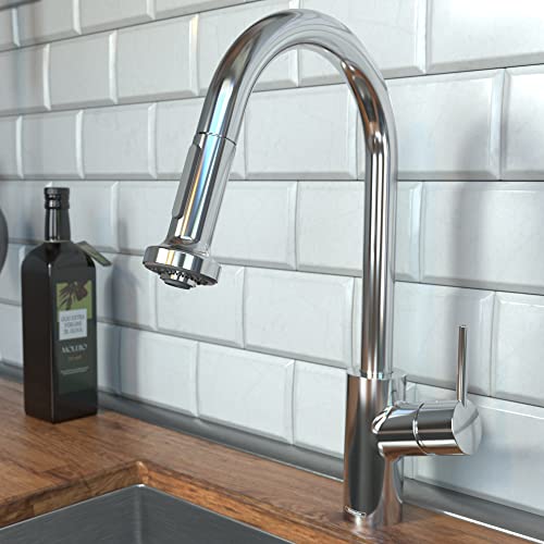 Polished nickel kitchen faucet with curved spout and pull-down spray head mounted above sink.