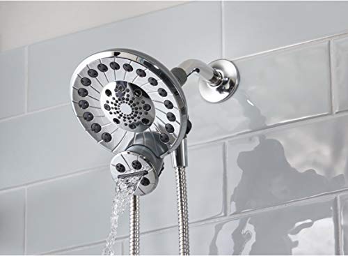 Chrome shower head with multiple spray holes mounted on white tile wall with handheld attachment and hose.