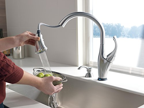 Arctic stainless steel soap and lotion dispenser with curved spout and pump mechanism.