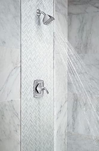 Chrome shower valve with single handle mounted on marble tile wall with water flowing from overhead showerhead.