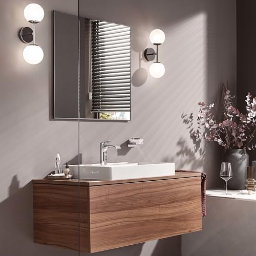 Chrome single-hole bathroom faucet with curved spout mounted above white rectangular sink.