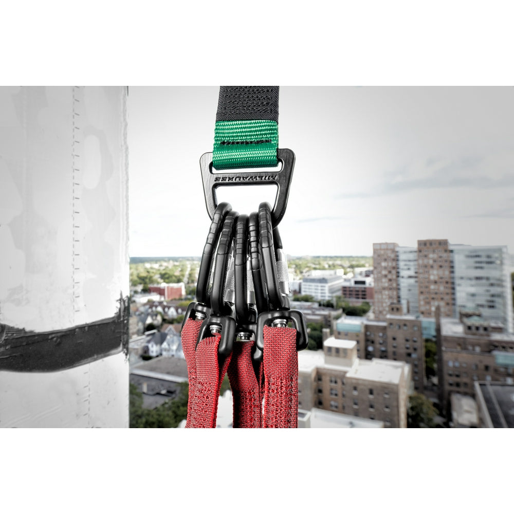 Black carabiner with green and black straps attached to red anchor cables on an elevated structure.