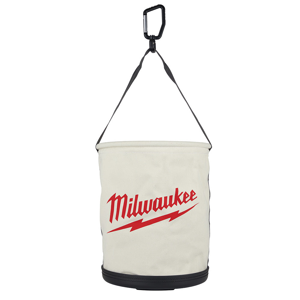 Cream canvas utility bucket with black carabiner handle, black straps, black base trim, and red Milwaukee logo on front.