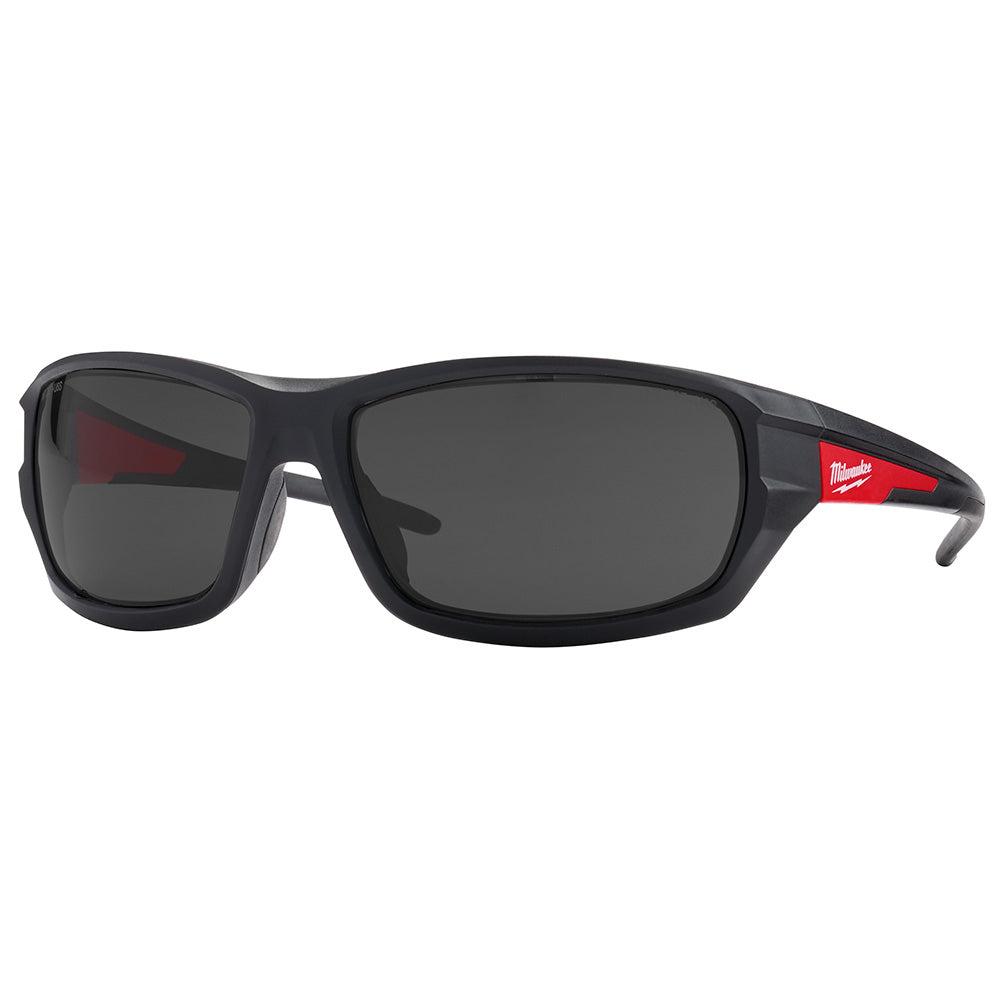 Black safety glasses with dark tinted lenses and red accents on the temples, Milwaukee branding visible.