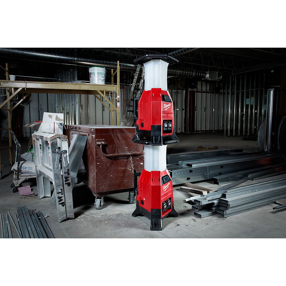 Red and black cylindrical work light with white diffuser top stacked in warehouse setting.