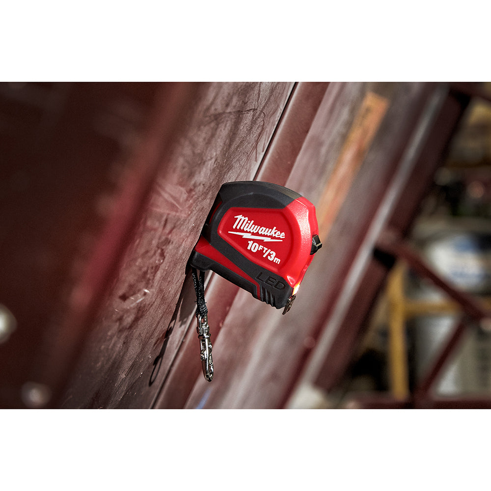 Red and black Milwaukee keychain tape measure with 10ft/3m capacity and retractable metal tape extended.