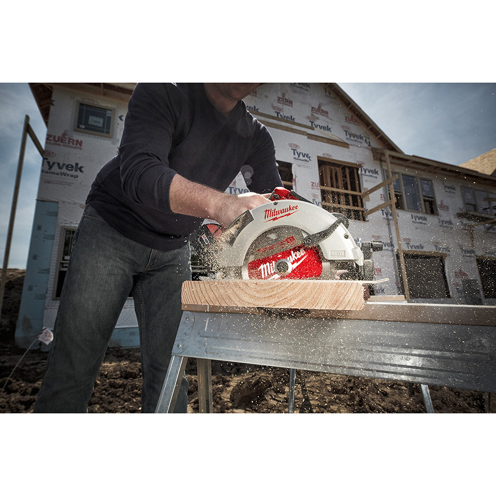 Milwaukee M18 brushless circular saw with red and white body cutting through wooden board, sawdust flying, held by person in 