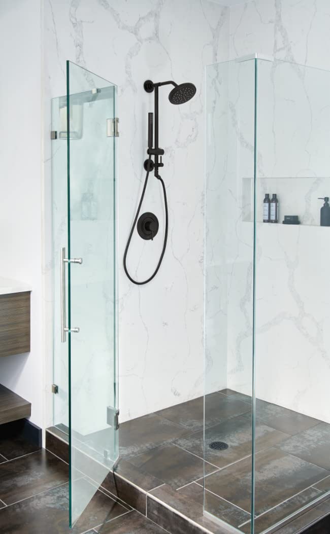 Brushed gold round shower head with handheld wand mounted on marble tile shower wall.