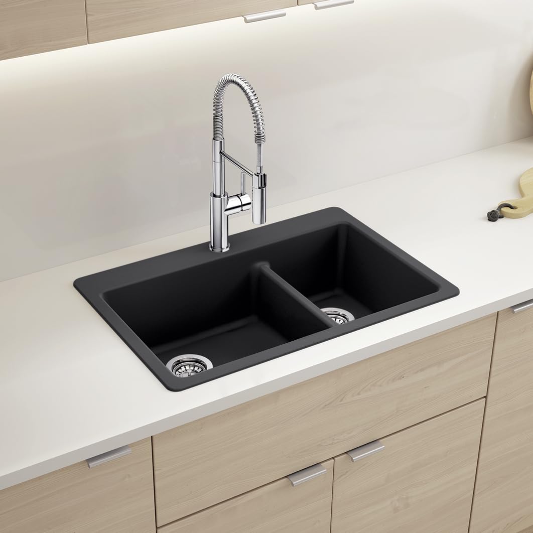 Coal black dual-bowl kitchen sink with low divider and chrome pull-down faucet installed in white countertop.