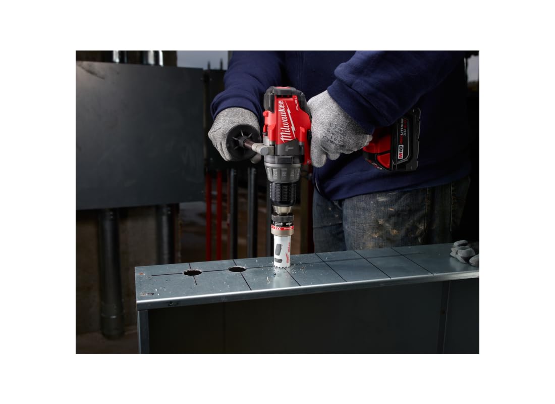 Milwaukee bi-metal hole saw with arbor installed in red drill, positioned over metal sheet with pre-marked holes.