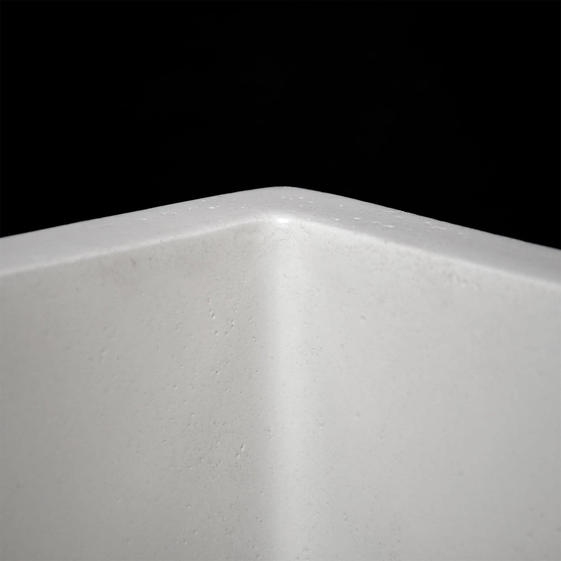 Rectangular bar sink with curved rim and speckled slate finish, shown from interior angled view against black background.