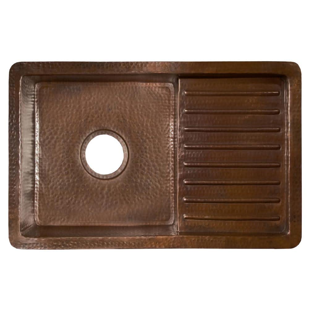 Hammered copper undermount sink with antique brown finish, single basin on left with drain hole and drainboard on right.