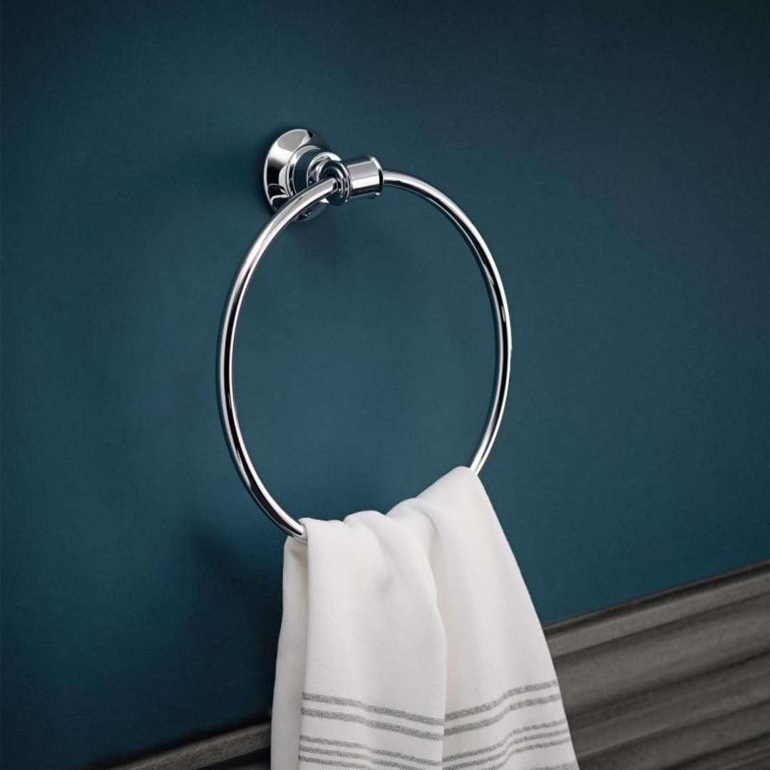 Chrome circular towel ring with wall-mounted bracket, holding a white hand towel with gray stripes.