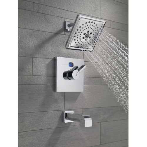Champagne bronze shower arm with square head mounted on gray tile wall, water streaming from showerhead.