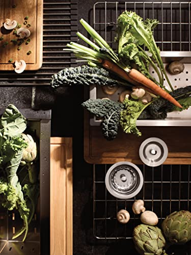 Stainless steel undermount sink with cutting board, drying rack, colander, and grid displayed with fresh vegetables and mushr