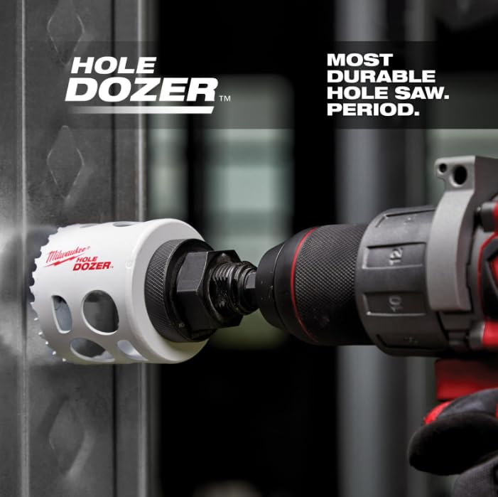 White and black bi-metal hole saw with red accents attached to power drill chuck against metal surface.