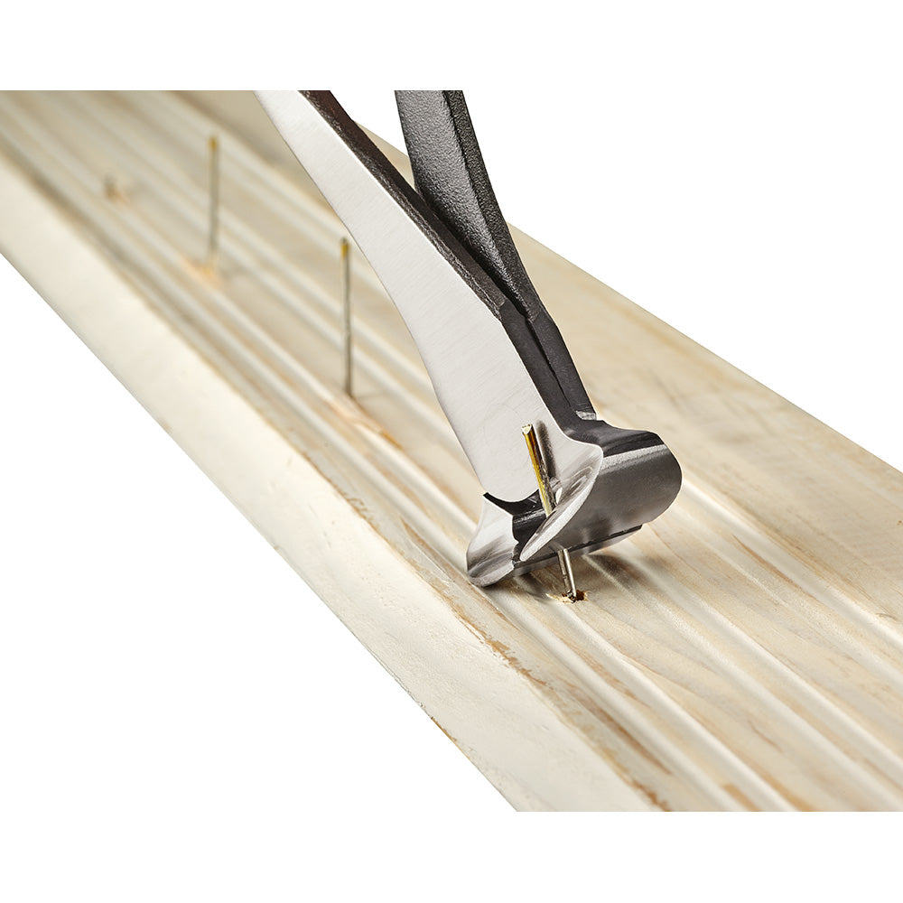Milwaukee nipping pliers with black and white handles cutting nails on light wood surface.