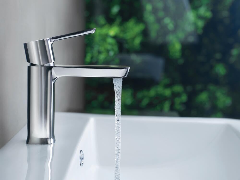 Chrome single-handle bathroom faucet with cylindrical body and lever handle, water streaming from spout into white sink.