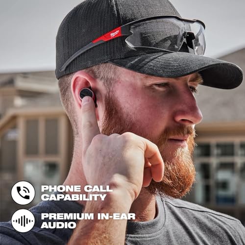 Black wireless earbud in person's ear with red accent and safety glasses on cap.