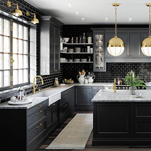 Brushed gold high-arc kitchen faucet with pull-down spray mounted at sink in black and white kitchen.