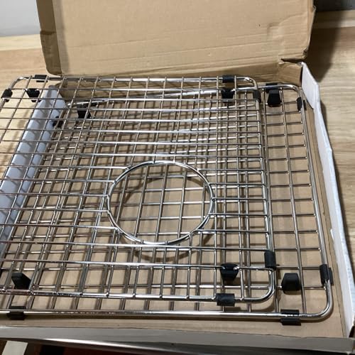 Stainless steel sink grid with square wire pattern and circular drain opening in cardboard box.