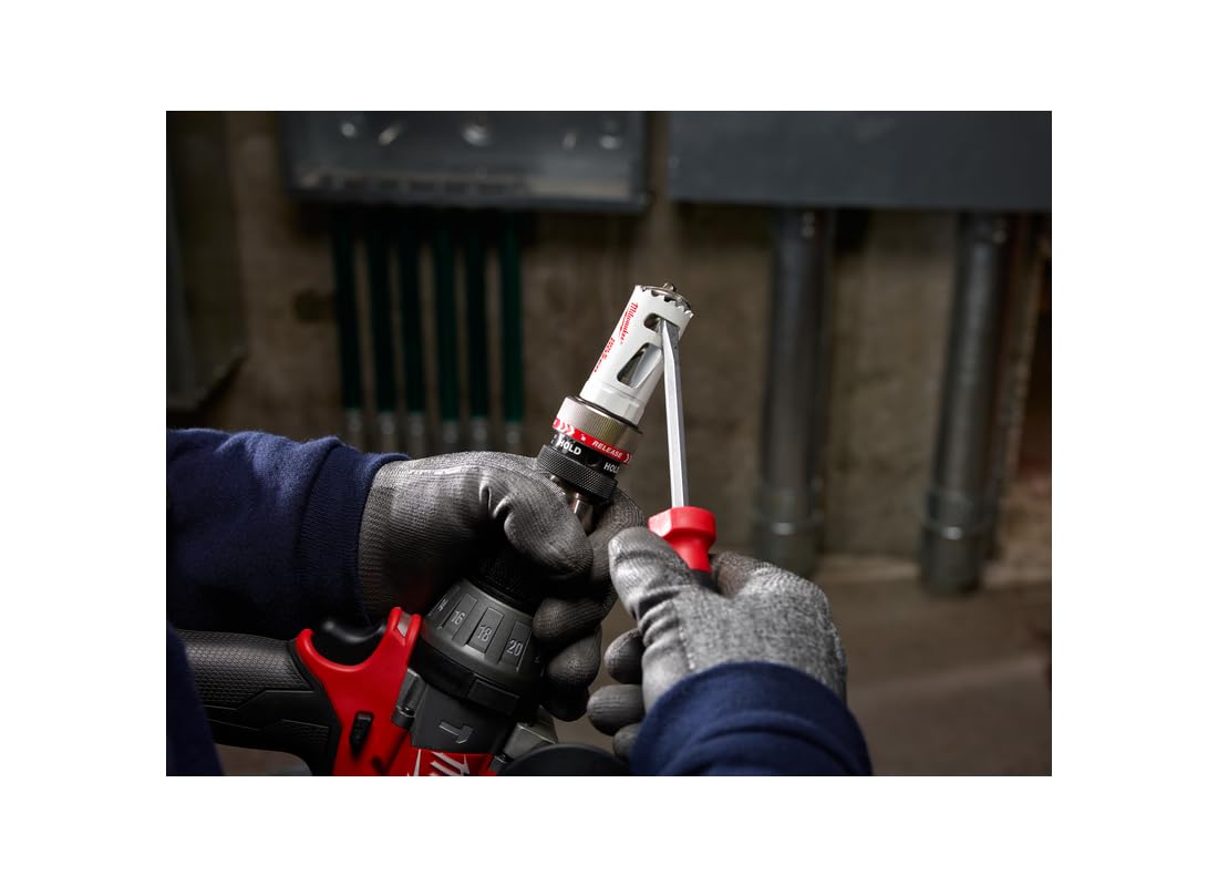 Milwaukee 2-1/4" bi-metal hole saw with white and red body held in gloved hands over drill press.