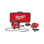 Milwaukee M18 cordless grease gun kit with battery, charger, hose, nozzle and red carrying case.