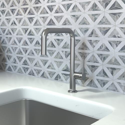 Brushed black chrome U-shaped kitchen faucet with single spray installed above a stainless steel sink against geometric tile 