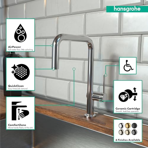 Chrome pull-down kitchen faucet with U-shaped spout mounted on sink countertop against white subway tile backsplash.