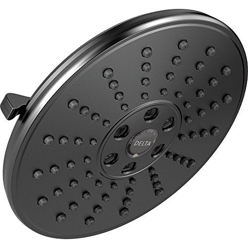Round matte black shower head with multiple water jets and adjustable control dial, mounted at angle.