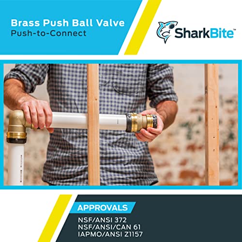 Brass ball valve with push-to-connect fittings being held by person in plaid shirt during installation.