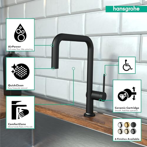 Matte black U-shaped kitchen faucet with single spray head mounted on countertop against white subway tile backsplash.