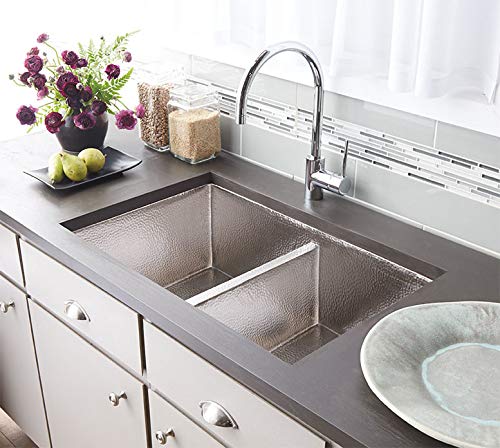 Brushed nickel dual-basin kitchen sink with pull-down faucet installed in dark countertop.