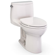 One-piece elongated toilet with closed seat lid in beige, featuring curved tank and bowl design with chrome handle.
