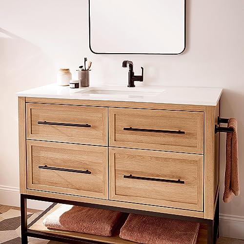Matte black towel bar mounted on wall beside wooden bathroom vanity with sink and faucet.