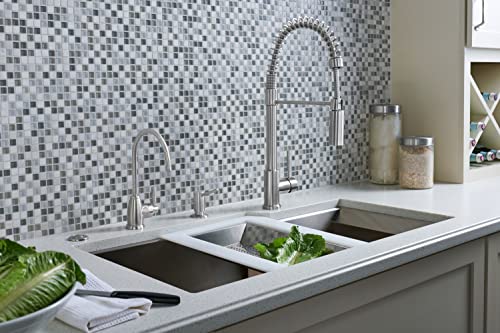 Satin nickel soap dispenser mounted on kitchen countertop next to faucet and sink.