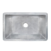 Brushed nickel single-basin undermount kitchen sink with hammered interior and drain hole, viewed from above.