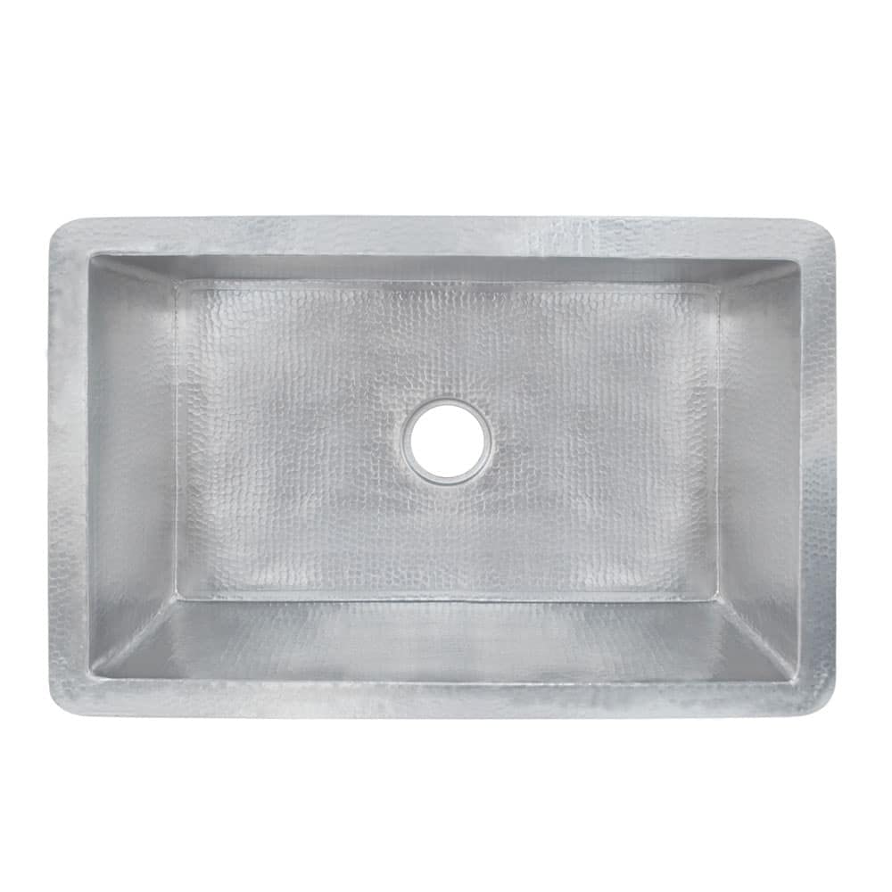 Brushed nickel single-basin undermount kitchen sink with hammered interior and drain hole, viewed from above.