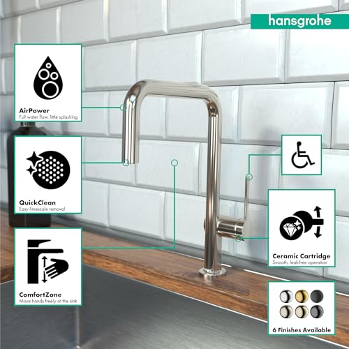 Polished nickel U-shaped kitchen faucet with single spray head mounted on wood countertop against white subway tile backsplas