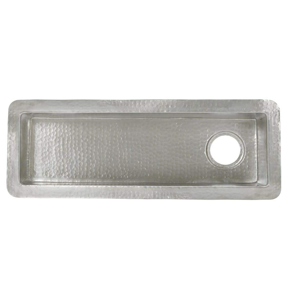 Rectangular hammered copper bar sink with single drain hole on right side, viewed from above.