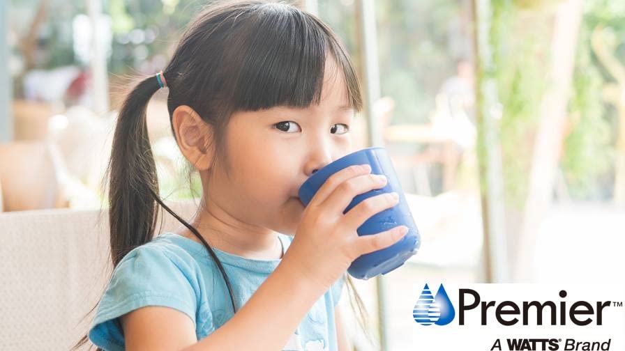 Child drinking from blue cup with Premier and Watts brand logos visible.