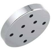Round chrome shower head with multiple black spray nozzles arranged in a pattern on the face.
